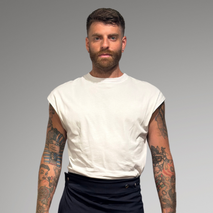 Man wearing a white t-shirt, black shorts, and white sneakers on a gray background