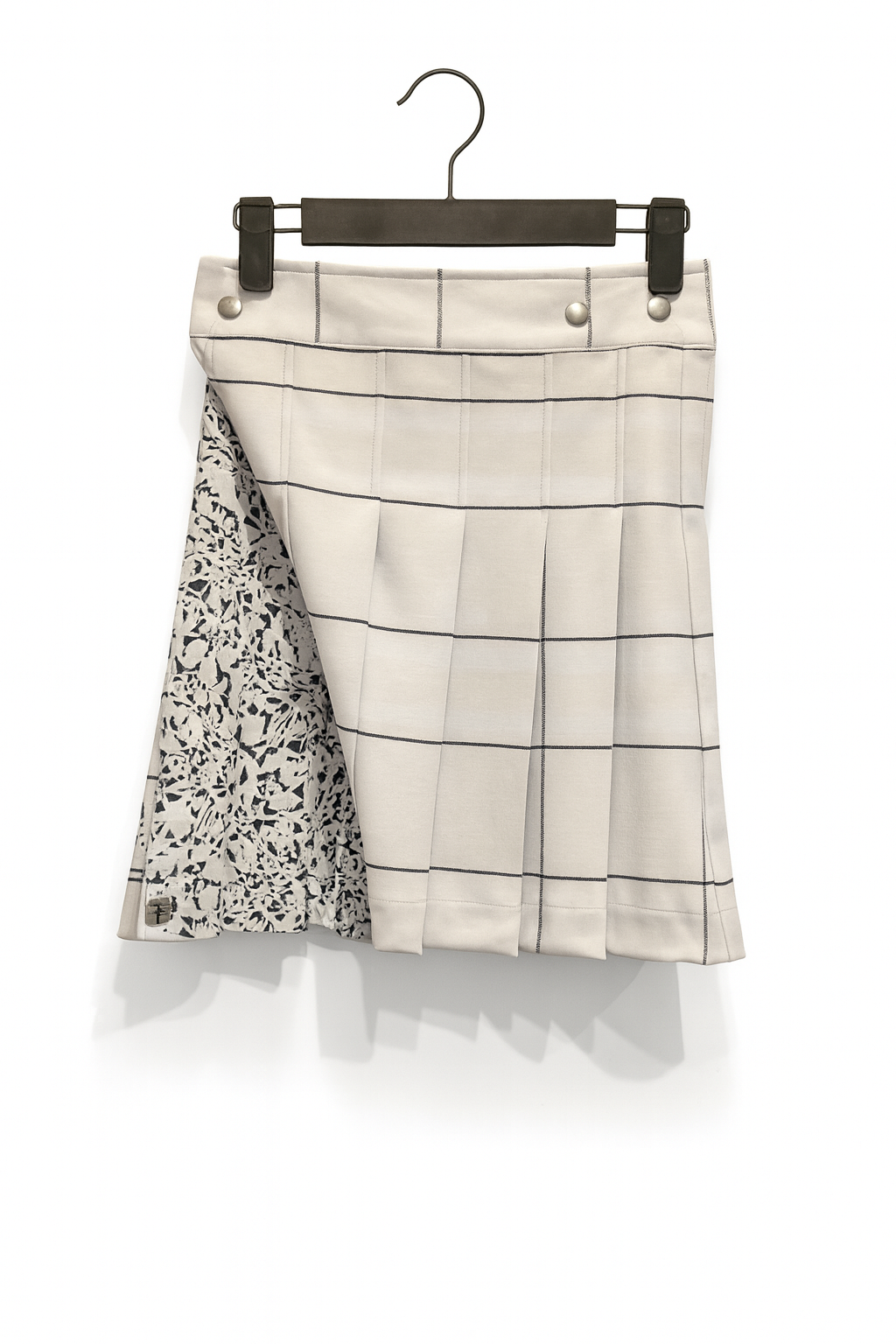 White kilt with checkered pattern on a hanger against a white background