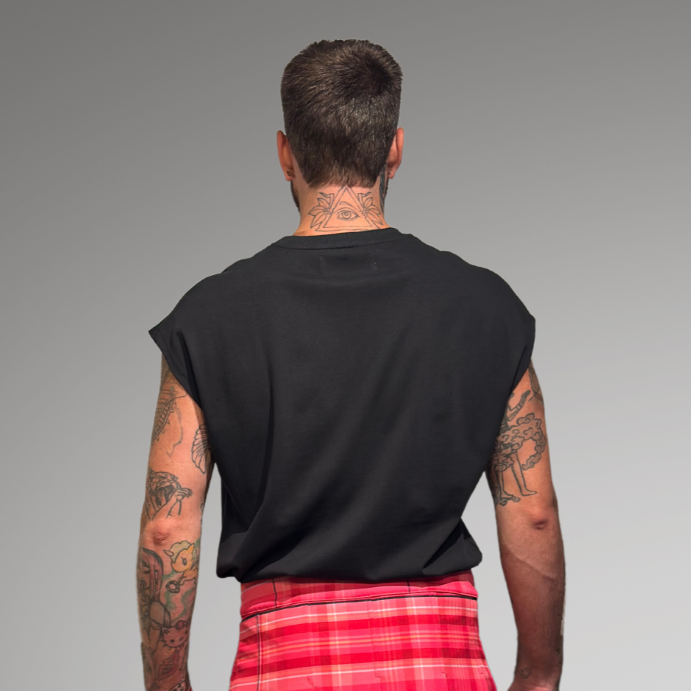 Person wearing a pink and red plaid skirt on a gray background