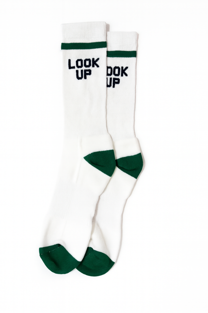 White socks with green accents and text 'LOOK UP' on a white background